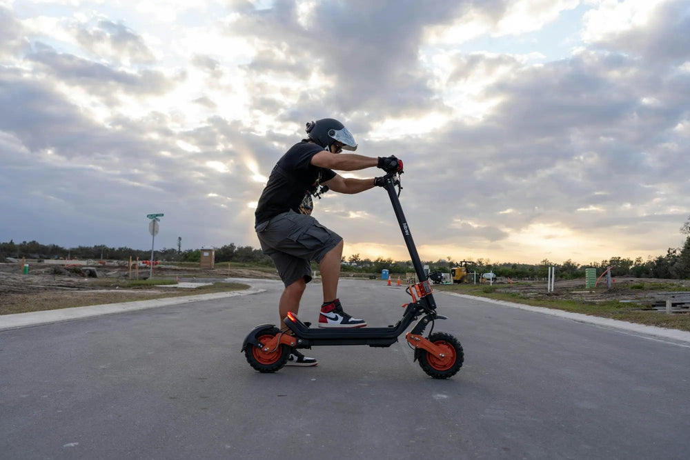 Helmeted male rider on a performance electric scooter outdoors